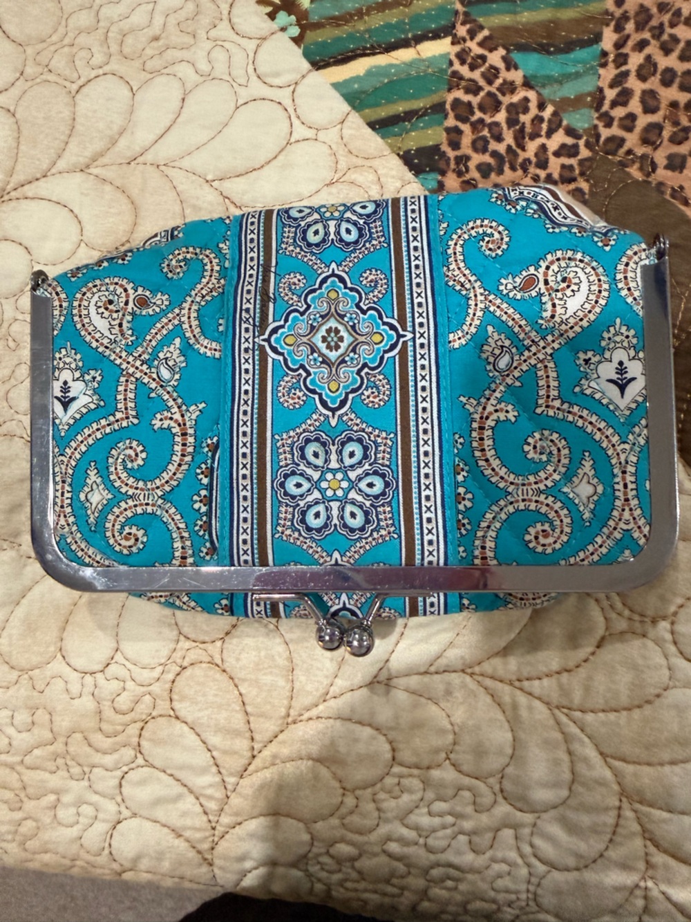 Vera Bradley kiss-lock cosmetic bag in a turquoise paisley pattern.